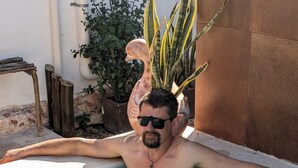 A man in a swimming pool with a plant on his head. - Beautiful Casa De Rose (Progreso)