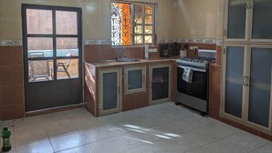 A kitchen with a gas stove, a sink, and cabinets. - Beautiful Casa De Rose (Progreso)