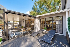 An outdoor patio with a dining area, lounge chairs, and a pergola. - Stunning Home w/ Heated Saltwater Pool & Pond View + 12 Guests + Great Location (Temple Terrace)