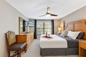 A bedroom with a bed, bedside table, nightstand, dresser, chair, and a ceiling fan. - Stunning Home w/ Heated Saltwater Pool & Pond View + 12 Guests + Great Location (Temple Terrace)