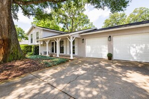 A two-story house with a covered porch, a garage, and a well-maintained lawn. - Stunning Home w/ Heated Saltwater Pool & Pond View + 12 Guests + Great Location (Temple Terrace)