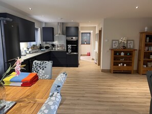 Enjoy cooking in this well-lit kitchen with a range hood, microwave, and dining table.