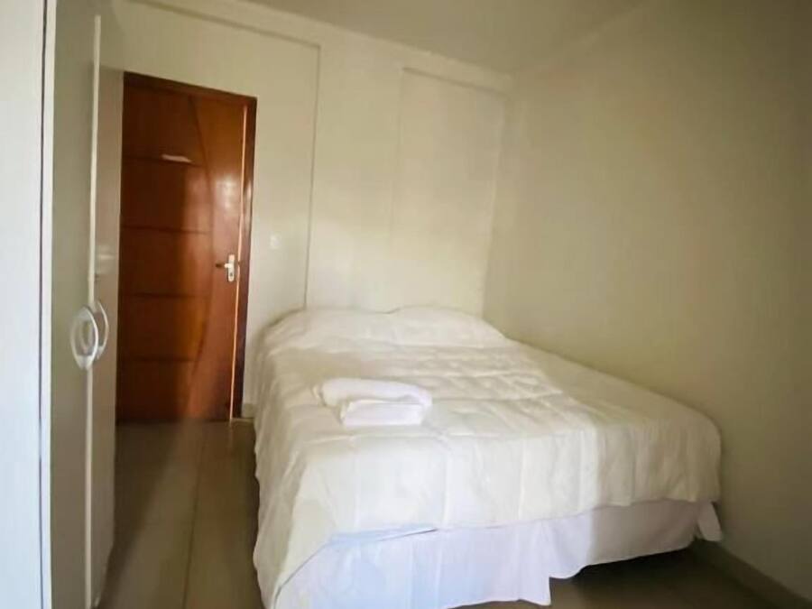 Un dormitorio con cama, puerta y suelo de baldosas.