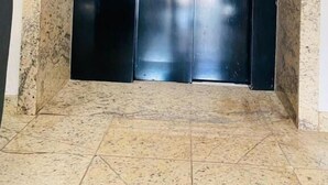 A black elevator with a logo featuring a shield and stars, and control buttons on the wall.