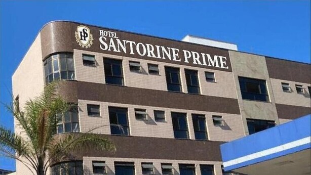 A multi-story building with a sign reading "HOTEL SANTORINE PRIME."