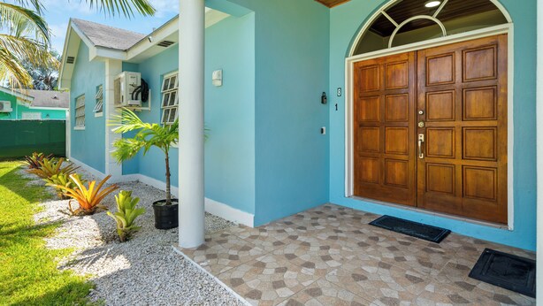A house with a large wooden door, a tiled entrance, and a small garden with plants. - Dreamers Getaway - Relaxing unit with large rooms, full kitchen, & fast Wi-Fi (Nassau)