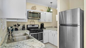 A modern kitchen with white cabinets, a stainless steel refrigerator, a microwave, a stove, and a sink. - Dreamers Getaway - Relaxing unit with large rooms, full kitchen, & fast Wi-Fi (Nassau)