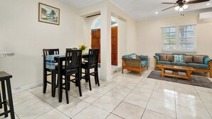 A spacious living area with a dining table, chairs, a sofa, and a ceiling fan. - Dreamers Getaway - Relaxing unit with large rooms, full kitchen, & fast Wi-Fi (Nassau)