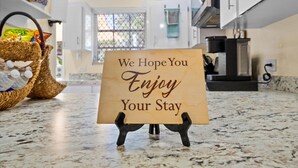 A kitchen counter with a sign that reads "We Hope You Enjoy Your Stay." - Dreamers Getaway - Relaxing unit with large rooms, full kitchen, & fast Wi-Fi (Nassau)