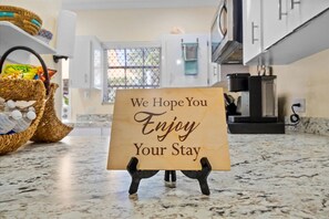 A kitchen counter with a sign that reads "We Hope You Enjoy Your Stay." - Dreamers Getaway - Relaxing unit with large rooms, full kitchen, & fast Wi-Fi (Nassau)