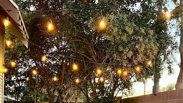 An outdoor seating area with wicker chairs and a table, surrounded by a brick wall and a tree. - Villa Verde - 5 miles to Disney! (Fullerton)