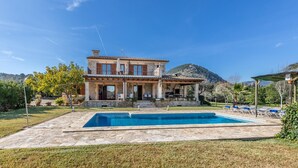 A two-story house with a swimming pool, stone exterior, and a mountain in the background. - L'Olivar Cánaves - Four Bedroom Villa, Sleeps 8 (Mallorca)