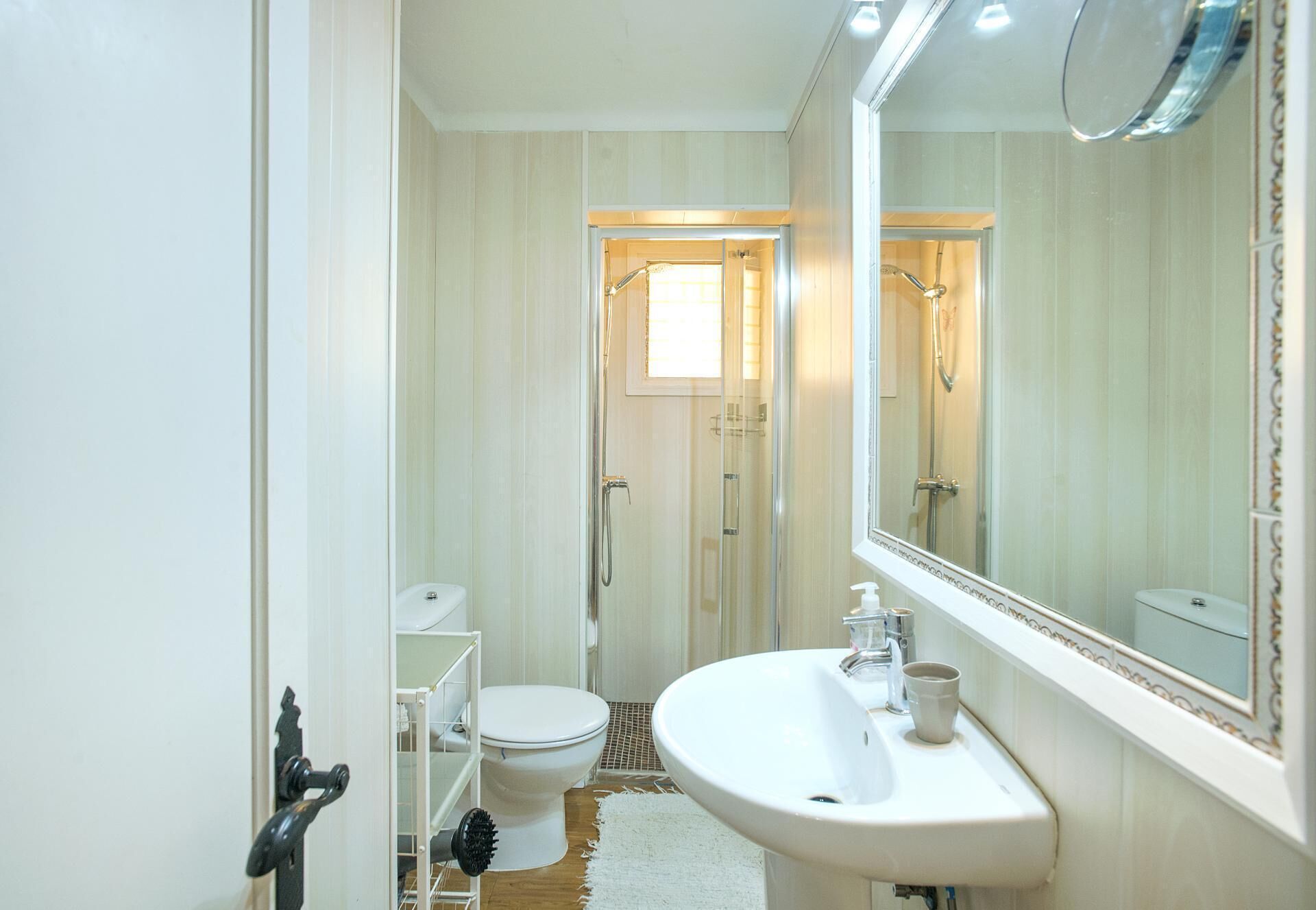 A compact bathroom with a toilet, sink, and shower.