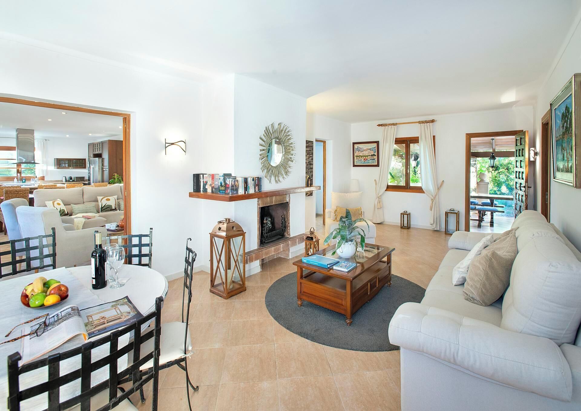 A spacious living area with a fireplace, a dining table with chairs, and a sofa.
