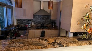 A modern kitchen with granite countertops, stainless steel appliances, and wooden cabinets. - BEAUTIFUL VIEWS ON PLAYAS GEMELAS BEACH (PUERTO VALLARTA)