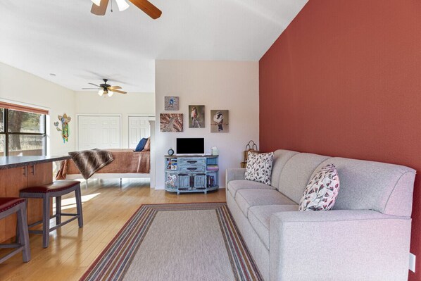 A living room with a sofa, a coffee table, a TV stand, and a fireplace.