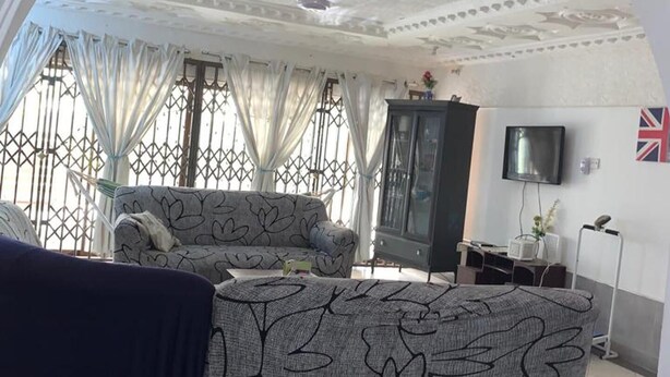 Ein Wohnzimmer mit einer Couch, einem Fernseher und einem Schrank.