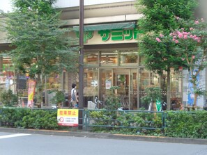 Ein Schaufenster mit einer grünen Schilderfassade, einem Verbotsschild und einer Fußgängerzone.