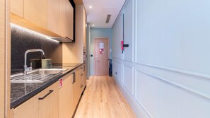 A modern kitchen with a stainless steel sink, wooden cabinets, and a black countertop. - Riverside Oasis by LovelyStay (Vila Nova de Gaia)