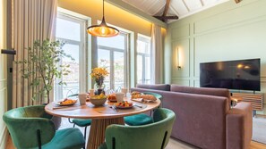 A dining area with a round table, chairs, and a vase of flowers. - Riverside Oasis by LovelyStay (Vila Nova de Gaia)