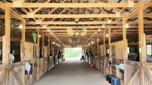 A barn with wooden stalls and a central aisle.