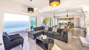 A modern living room with a large sectional sofa, a coffee table, and pendant lighting.