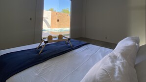 Ett hotellrum med en säng, ett fönster och en luftkonditioneringsanläggning.
