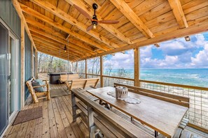 A wooden deck with a table and benches, overlooking a scenic view.