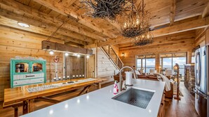 Una cocina amplia con una isla grande, vigas de madera y vistas al mar.