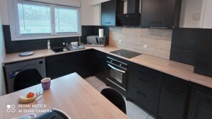 A modern kitchen with black cabinets, a microwave, and a sink.