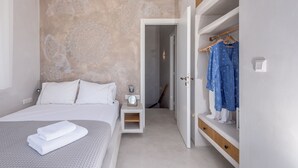 Een slaapkamer met een bed, nachtkastje en een kledingkast.