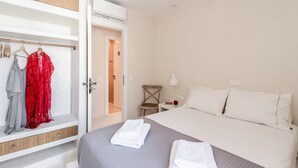 Une chambre d’hôtel comprenant un lit, une armoire, une chaise et une table de chevet.