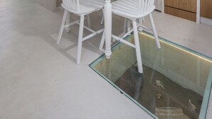 Une cuisine moderne avec des meubles blancs, un réfrigérateur vintage et un coin repas avec des chaises et une table, le tout dans des tons blancs.