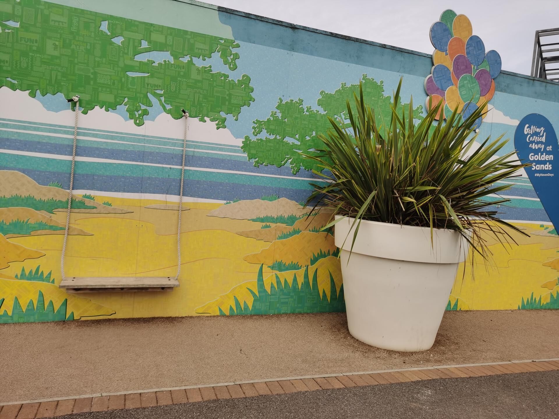 A mural with a swing and a potted plant.