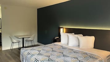 Una habitación de hotel moderna con una cama grande, un escritorio y dos sillas.