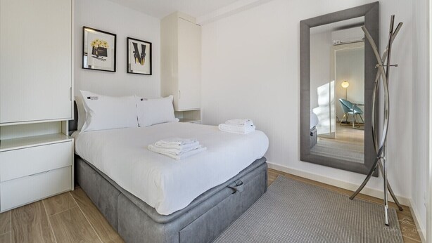 A modern hotel room with a large bed, a wardrobe, a mirror, and a view of the bathroom. - Nomad's Lux - 1BDR The Silent Nest in Bonfim (Porto)