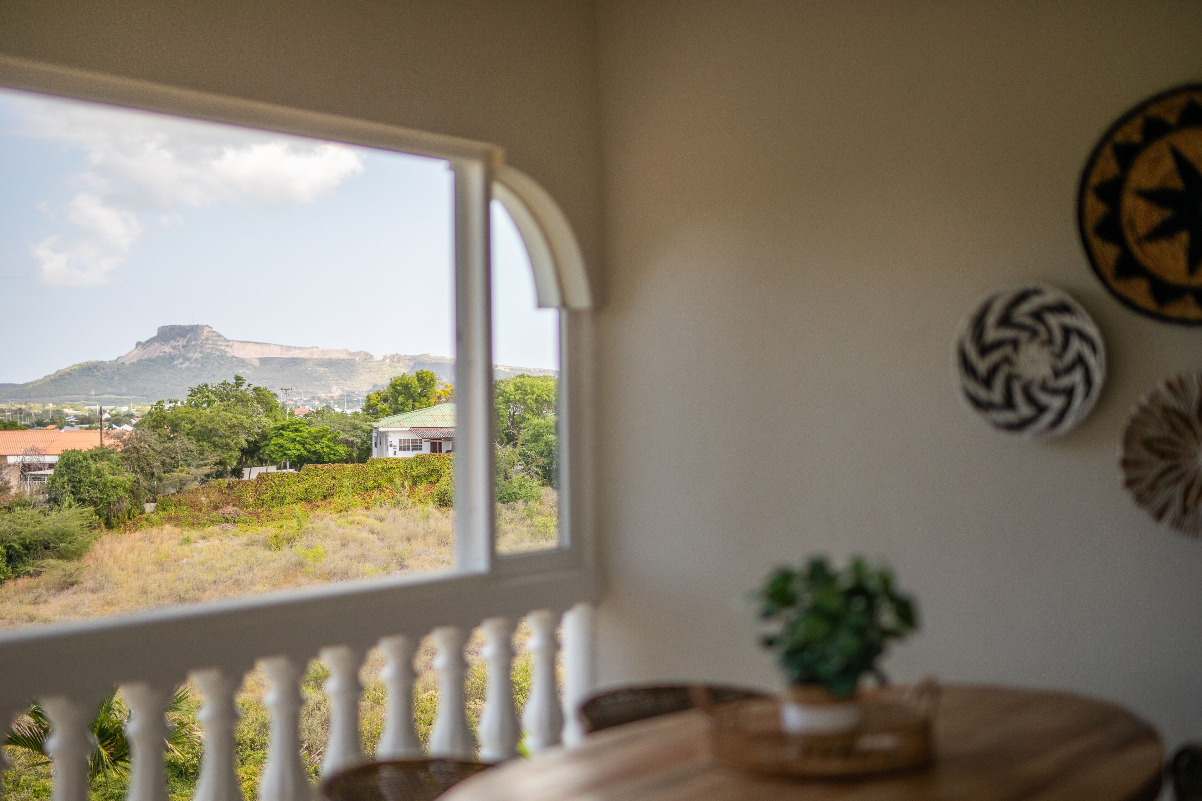 Una habitación con vistas a una montaña y vegetación.