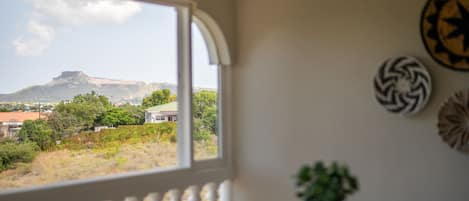 Una habitación con vistas a una montaña y vegetación.
