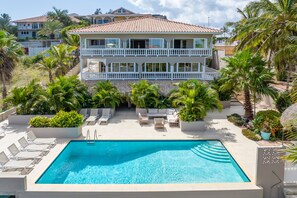 A two-story building with a swimming pool, surrounded by palm trees and lounge chairs. - JT Apartments Jan Thiel  (Jan Thiel)