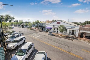 A street view with parked cars, a building with a sign 'The Lodge', and a clear blue sky. - Luxury Condo Overlooking Downtown Fairhope #201 (Fairhope)