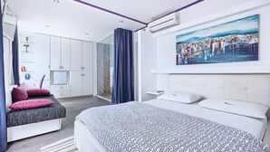 Ein modernes Schlafzimmer mit Bett, Dusche und einem Bild an der Wand.
