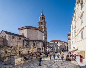 A historic square with stone buildings, a prominent tower, and outdoor seating areas. - Luxury Room Ana 2 in the Heart of Split (Split)