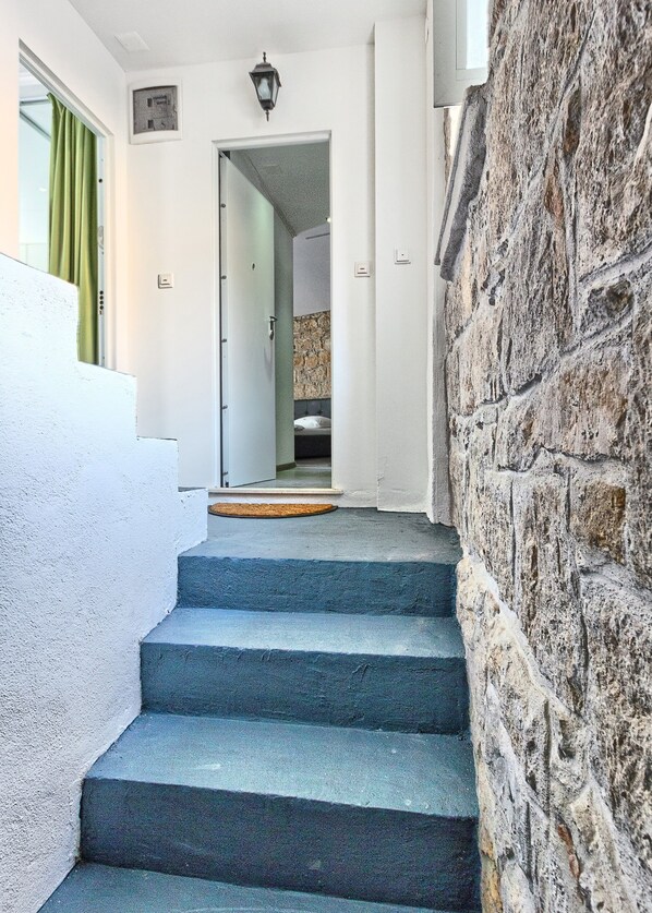 A staircase leading to a bedroom with a stone wall and a door with a light switch. - Luxury Room Ana 1 in the Heart of Split (Split)
