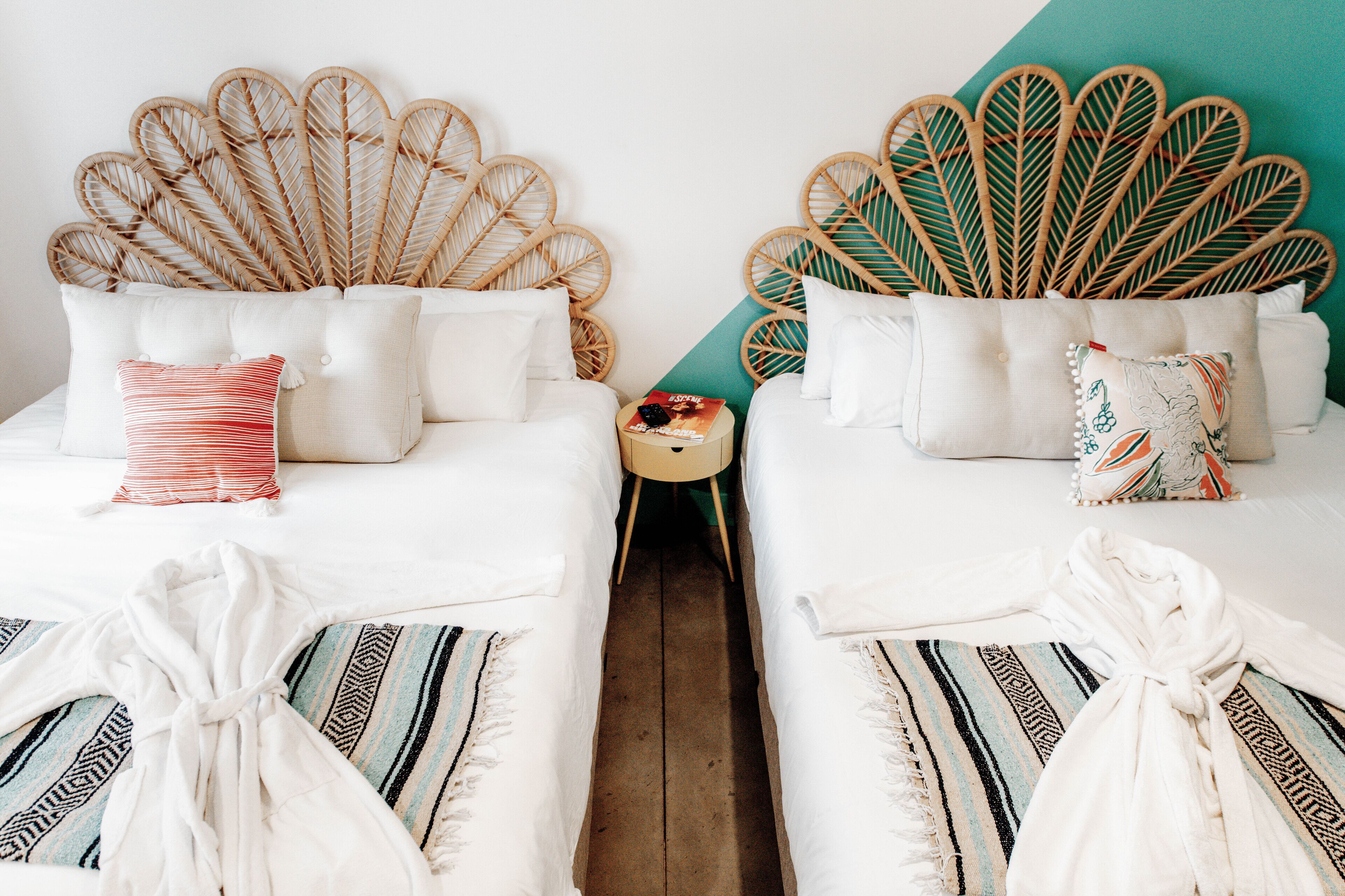 A hotel room with two beds, each with a unique leaf-shaped headboard.