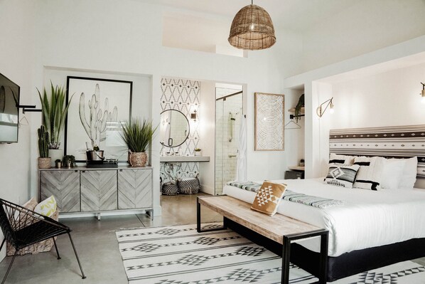 A modern bedroom with a bed, bedside table, and a hanging light fixture.