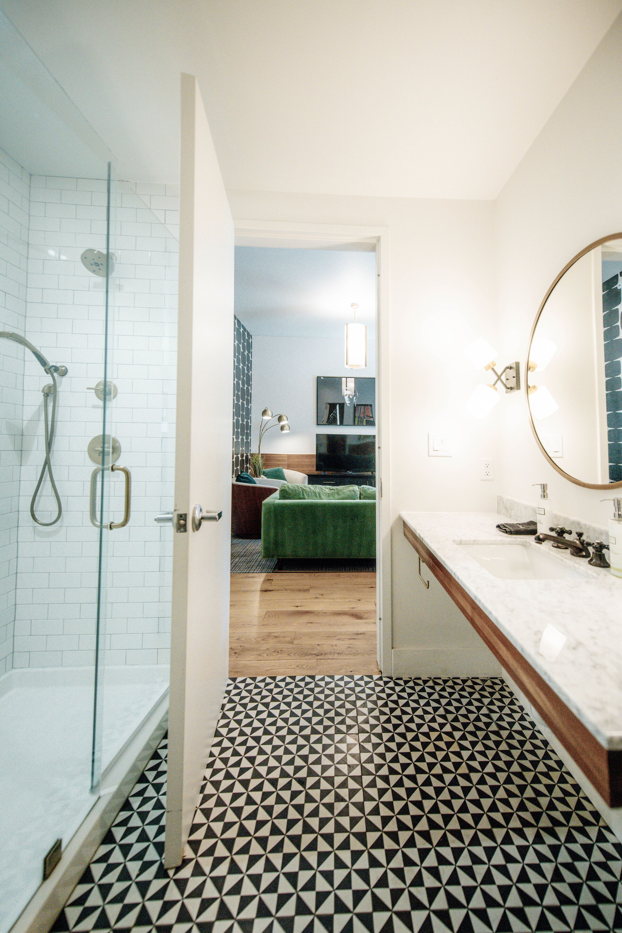 Une salle de bain avec une douche, un lavabo et un miroir.