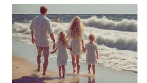 Una familia caminando sobre una playa arenosa con olas al fondo.