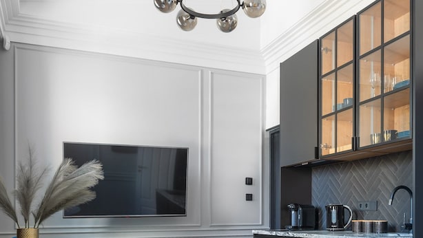 Una cocina moderna con isla integrada, muebles oscuros y salpicadero con patrón de espiga.