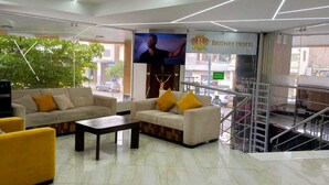 A hotel lobby with sofas, a coffee machine, and a TV screen. - BRITNEY HOTEL MACHALA (Machala)
