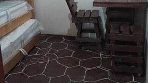 A small room with a bunk bed, a desk with a chair, and a tiled floor. - Ocean View (Riohacha)